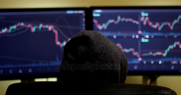 Corretor de bolsa está trabalhando no mercado financeiro em uma sala de monitoramento escuro com telas de exibição — Vídeo de Stock