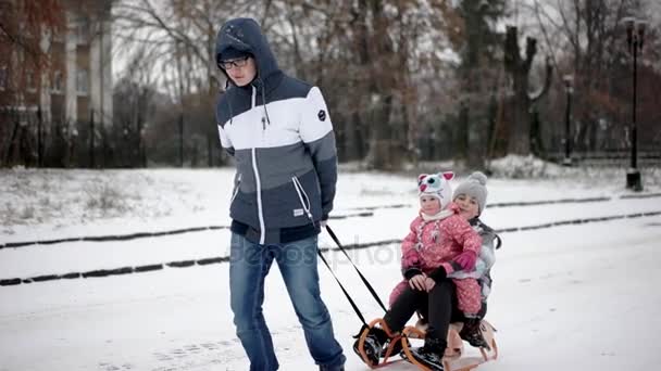 Fratello maggiore tirato suo minore sorelle su un slitta — Video Stock