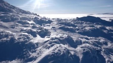 Seyahat sırt çantaları ile bulut deniz kıyısında tarafından uzak tepeleri manzaralı bulutların üzerinde bir kış yürüyüş yapmak