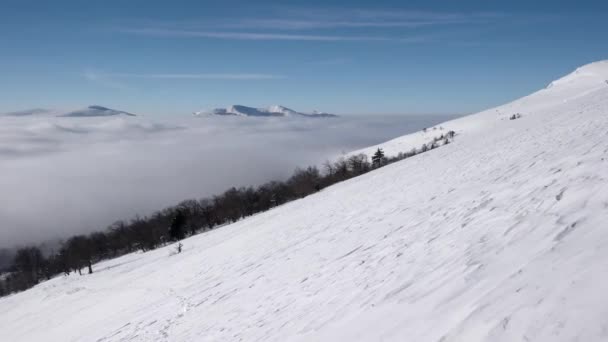 Zimní výšlap nad mraky s výhledem na vzdálené vrcholky pobřeží moře mraků — Stock video