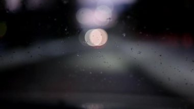 Gece sürüş. Ön cam görünümü ve bulanık araba şehir içinde. Araba penceresinden bulanık ve yağmurlu görünümü