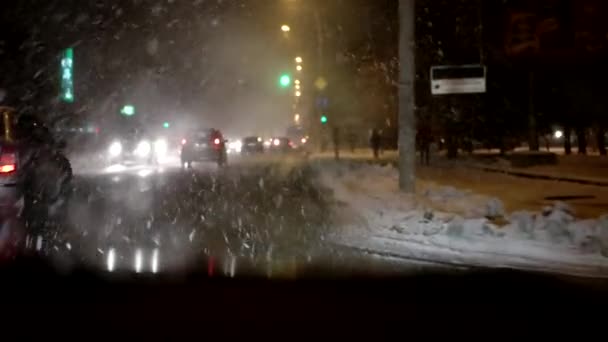 Stadsverkeer, rijden in de nacht sneeuwval, de Blizzard, de Ice Storm, niet-vliegende weer, natte sneeuw op de voorruit. Slechte slechte zichtbaarheid van laag. — Stockvideo