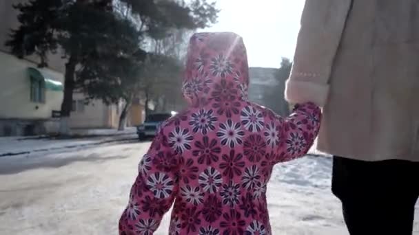 冬の雪に覆われた堤防路地で彼女の母親と一緒に歩いて 3 歳の女の子。ステディカム ショット — ストック動画