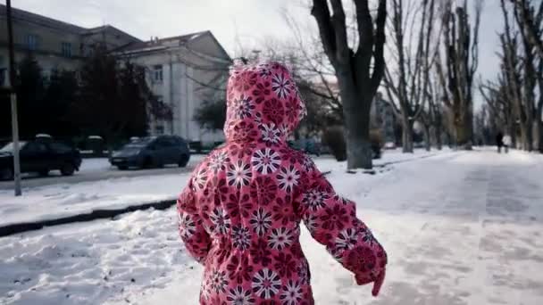 Garota de 3 anos se divertindo e correndo por Snow Covered Embankment Alley no inverno. Steadicam lenta movimento tiro — Vídeo de Stock