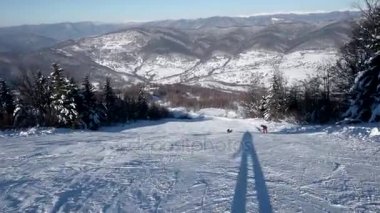 Hızlı kayakçı karlı yamaç aşağı tarafında açık gökyüzü ve karlı dağda bozulmamış bir günde Rides