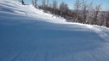Hızlı kayakçı karlı yamaç aşağı tarafında açık gökyüzü ve karlı dağda bozulmamış bir günde Rides