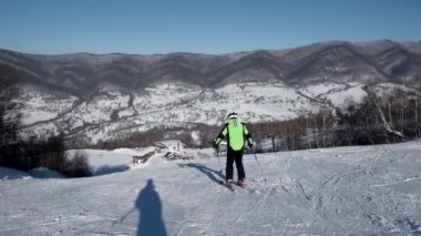 Arkadan görünüş karlı yamaç aşağı profesyonel kayakçı oymacılık