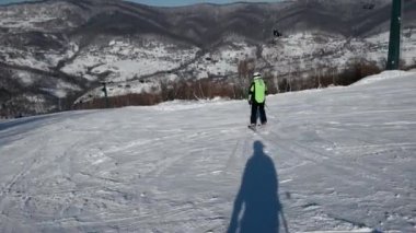 Ağır çekim arkadan görünüş karlı yamaç aşağı profesyonel kayakçı oymacılık