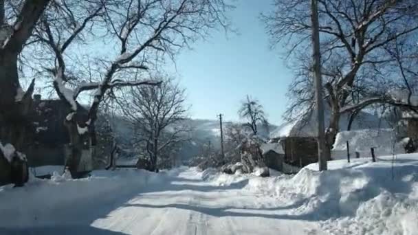 Conducir un coche en la carretera rural en invierno. Nieve y hielo en la autopista y cerca de montañas y colinas. Punto de vista en primera persona a través del parabrisas . — Vídeo de stock