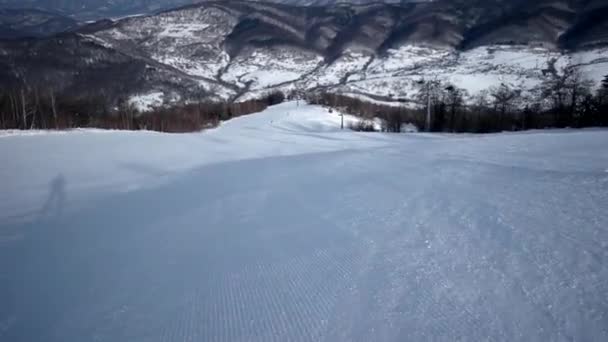 专业滑雪雕刻下来在雪坡上慢动作后视图 — 图库视频影像