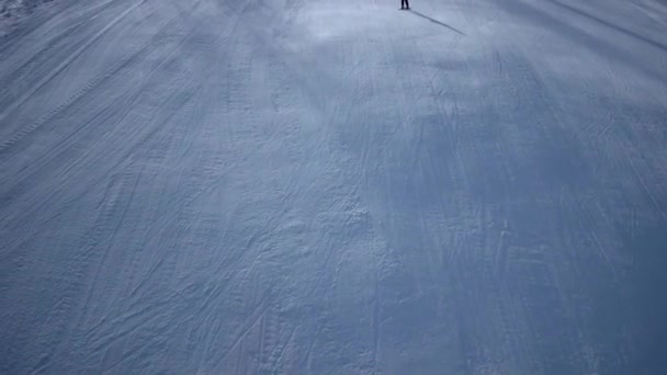 Tiro aéreo de esquiadores descendo a encosta de esqui, sombras longas na neve branca. Recreação de Inverno e Desportos — Vídeo de Stock