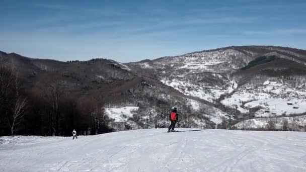 Lassú mozgás hátulnézet profi síelő faragás lefelé a havas lejtőn — Stock videók
