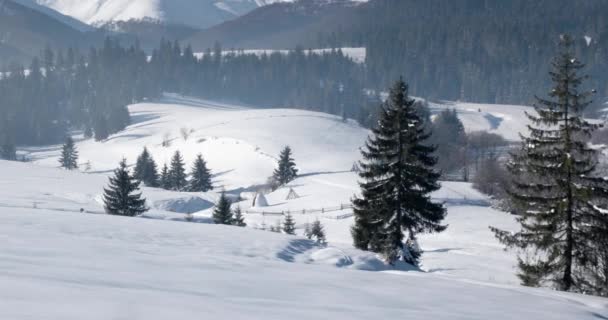 Vista panorámica de las montañas cubiertas de nieve y cumbres de montaña, pueblo tradicional y paisaje rural en invierno — Vídeo de stock