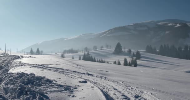 Vista panorámica de las montañas cubiertas de nieve y cumbres de montaña, pueblo tradicional y paisaje rural en invierno — Vídeos de Stock