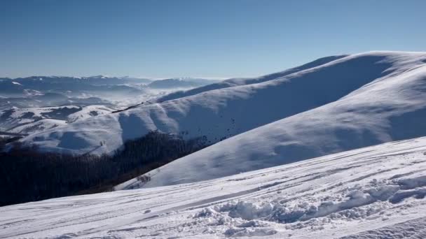 山脊和雪覆盖山脉和乡村景观在冬季晴天平移视图 — 图库视频影像