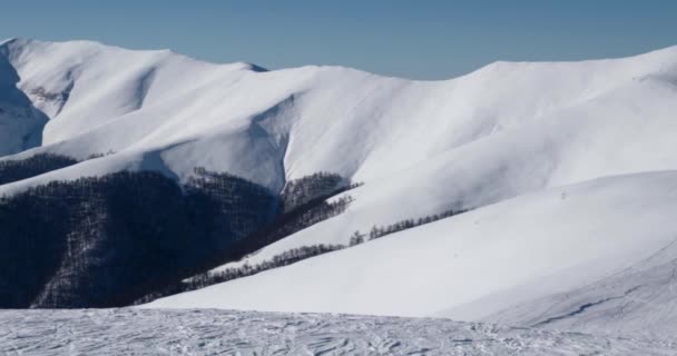 Bergsryggen och snö täckte bergen och landsbygdens landskap i solig vinterdag panorering Visa — Stockvideo