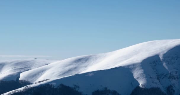 Κορυφογραμμή του βουνού και το χιόνι κάλυψε βουνά και Αγροτικού τοπίου σε χειμώνα Panning προβολή ηλιόλουστη μέρα — Αρχείο Βίντεο