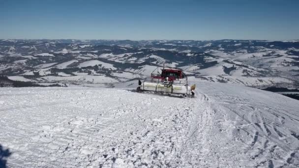 Esquiadores montando en la espalda de un gato de nieve en una montaña cubierta de nieve en un día soleado de invierno — Vídeos de Stock