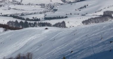 Snowcat kayakçı arkadaki bir kar üzerinde sürme ile dağ tepe kış güneşli gün kapalı.