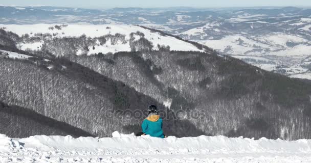 Muž snowboardista hodinky a odpočinku na vrchol hory sněhu lyžařského střediska — Stock video
