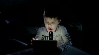 Genç çocuk onun dijital Tablet evde oyun oynarken dalmış