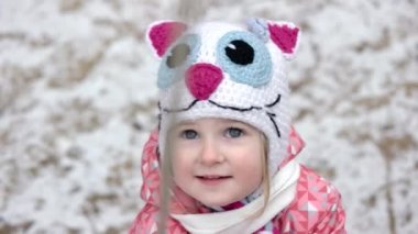 Kar üzerinde açık oynayan sevimli küçük sarışın kız. 3 yaşındaki kız portresi yakın çekim