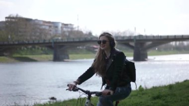 Kentsel genç Casual Hipster kızla Nehri yakınında onu bisiklet sürme güneş gözlüğü