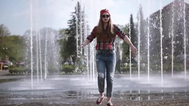 Adolescente casual hipster chica en gafas de sol feliz funky bailando freestyle en frente de la ciudad fuente — Vídeo de stock