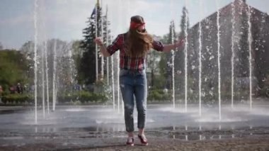 Güneş gözlüğü mutlu Funky dans serbest şehir çeşme önünde genç Casual Hipster kız