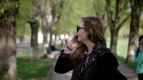 Stedelijke Teenage Casual Hipster meisje in zonnebril met behulp van een Smartphone terwijl permanent op stad loopbrug — Stockvideo