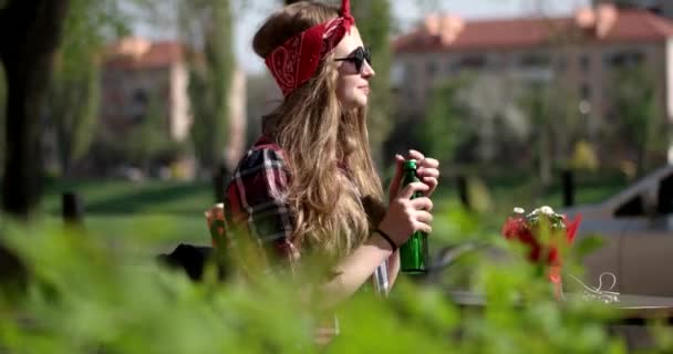 Городской тинейджер-хипстер Счастливая девочка в Санта-Клаусе и Жанна Смит и пьют воду на террасе в солнечный день — стоковое видео