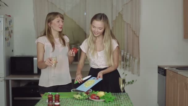 Mulheres cozinhando alimentos em uma cozinha e falando bebendo champanhe sorrindo rápido 50fps comida saudável — Vídeo de Stock