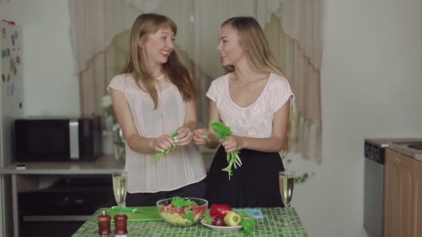 Frauen kochen Salat lächelnd in der Küche und reden über gesunde Ernährung — Stockvideo