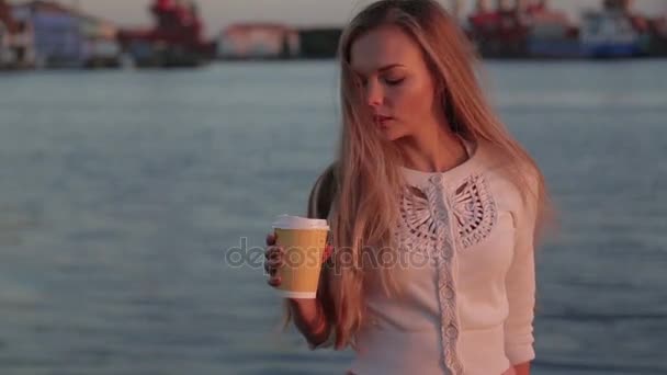 Vrouw drankje cofee kijken bij zonsondergang rivierhaven — Stockvideo