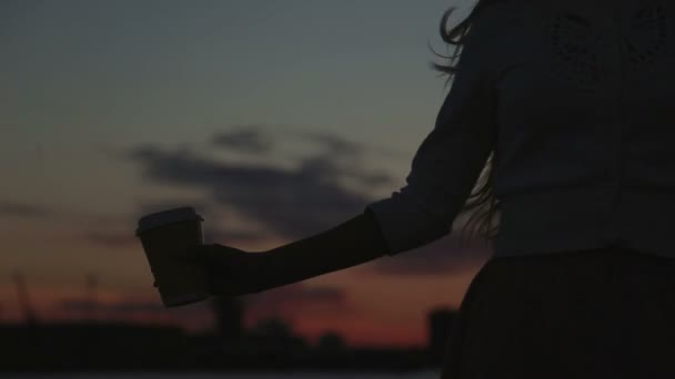 Femme boire cofee regarder au coucher du soleil sauter et danser rivière port gros plan — Video