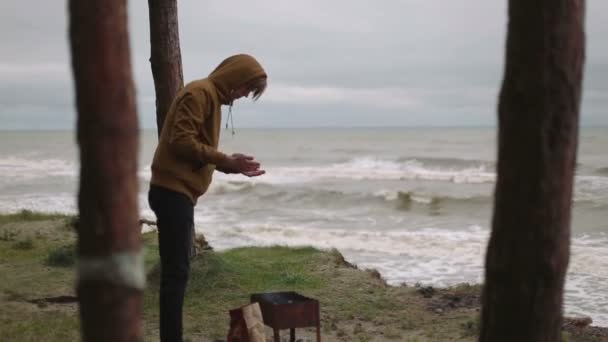 Hombre enciende brasas en el bosque de brasero y el mar hd — Vídeos de Stock