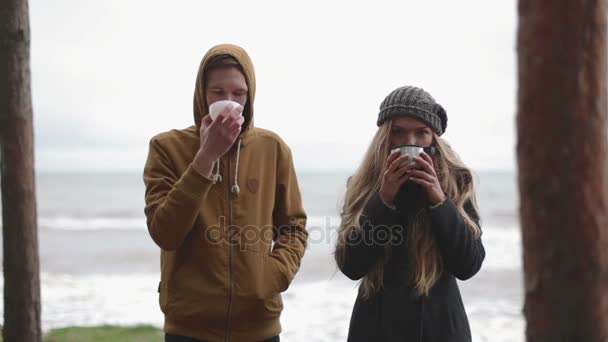 Pití v chladném počasí. muž a žena pít čaj z termosky — Stock video