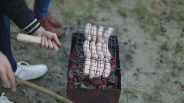 Churrasco browned salsichas na grelha quente, uma pessoa virar e colocar em cima de braseiro closeup — Vídeo de Stock