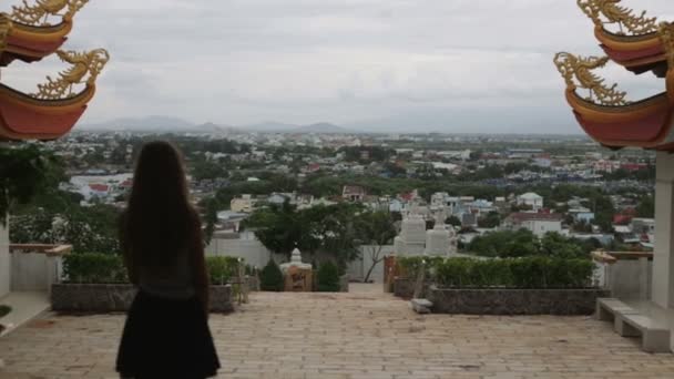 Flickan ser utsikten över staden från templet på berget Vietnam Hd — Stockvideo