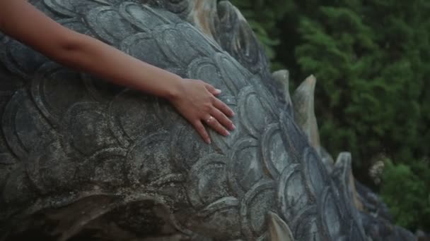 Женщина поднимается по лестнице дракона. прикосновение к весам рук крупным планом Медленное движение — стоковое видео