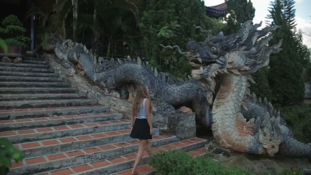 Hermosa mujer sube la escalera del dragón. tocar una escamas de mano Movimiento lento — Vídeo de stock