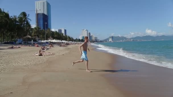 Прекрасный пляж. человек, прыгающий в волнах — стоковое видео