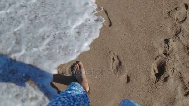 Man lopen op zand strand, zachte golven zijn voeten wassen. — Stockvideo