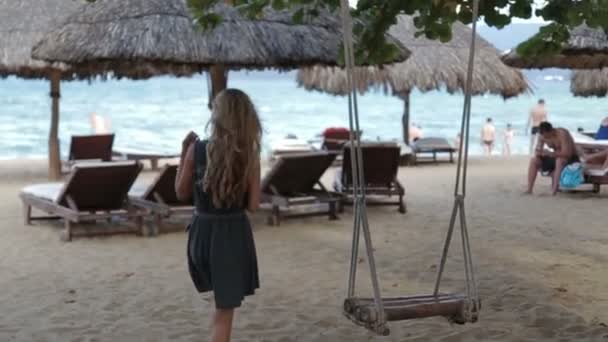 年轻女人放松的秋千在海滩上 — 图库视频影像