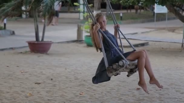 Jovem mulher relaxar no balanço na praia — Vídeo de Stock