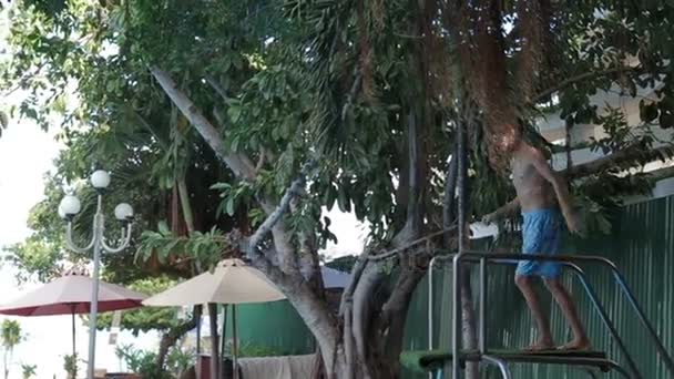 Uomo sorridente alla macchina fotografica e saltando in piscina , — Video Stock