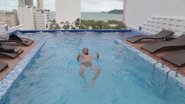 Mannen som simmar i en roof top lyx pool. — Stockvideo