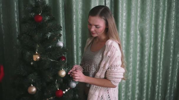 10 代の少女がクリスマス ツリーを飾る — ストック動画