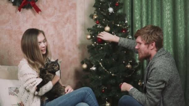 Pareja hombre con la mujer en el árbol de Navidad — Vídeos de Stock