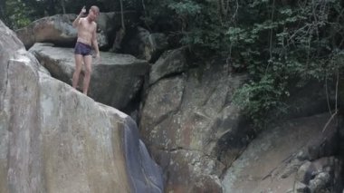 Genç adam su şelale kayaların üzerinden atlama